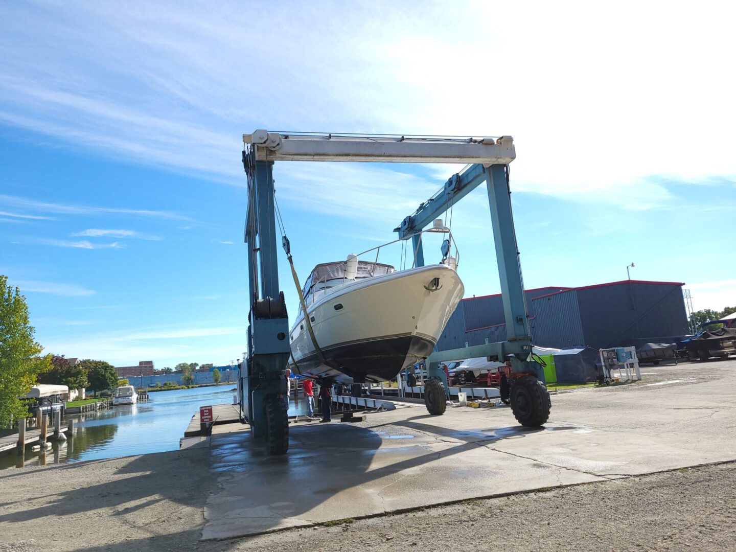 Boat being lifted by a large crane.